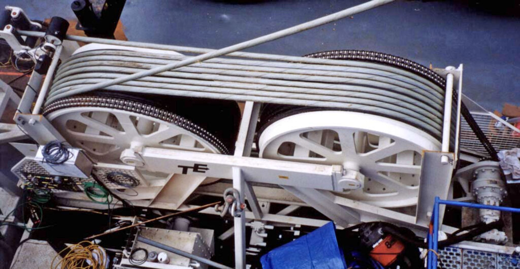 Industrial cable drum assembly with multiple steel cables wound on large white spools mounted on a metal frame